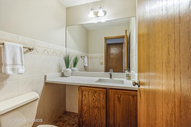 bathroom with tile walls, vanity, and toilet