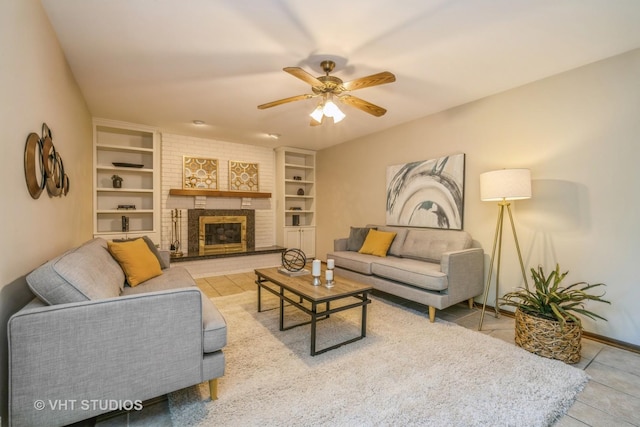 living room with light tile patterned flooring, a fireplace, ceiling fan, and built in shelves