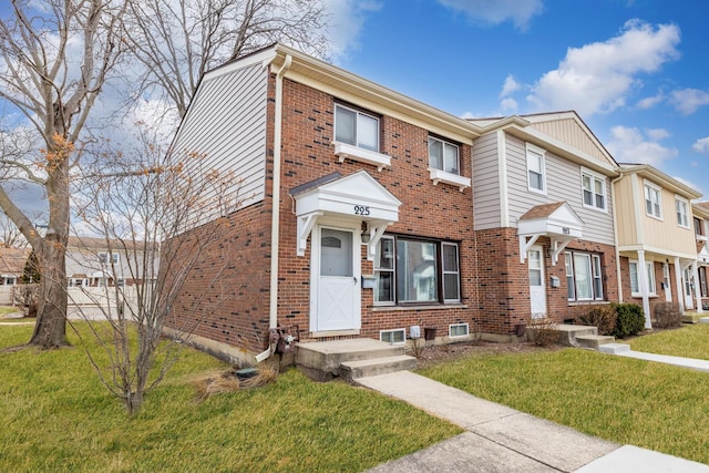 townhome / multi-family property featuring a front lawn