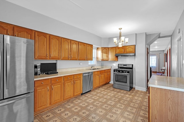 kitchen with pendant lighting, stainless steel appliances, sink, and a notable chandelier