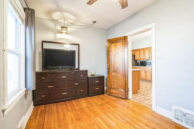 bedroom with ensuite bath and light wood-type flooring