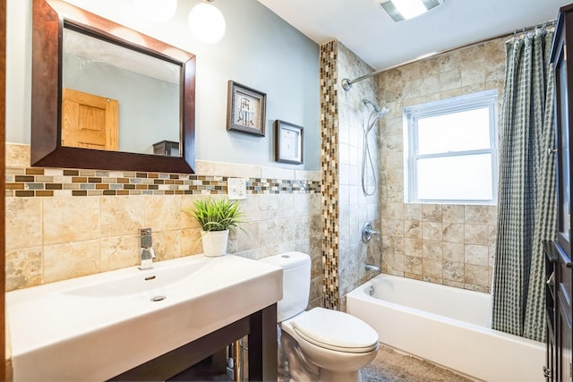 full bathroom featuring vanity, toilet, shower / bath combo with shower curtain, and tile walls