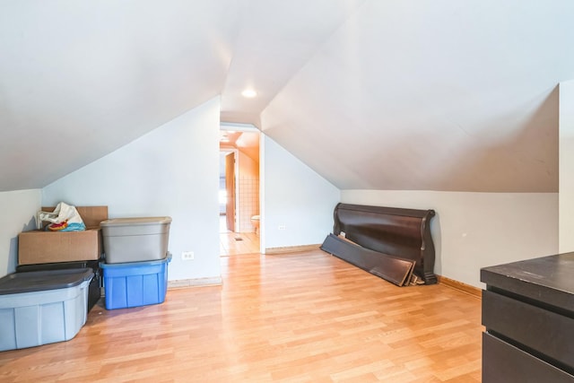 additional living space with vaulted ceiling and light hardwood / wood-style floors