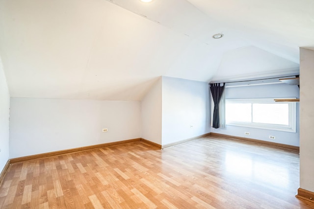 bonus room featuring lofted ceiling and light wood-type flooring