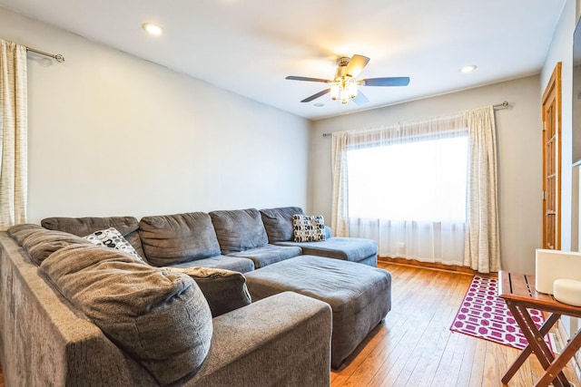 living room featuring light hardwood / wood-style flooring and ceiling fan