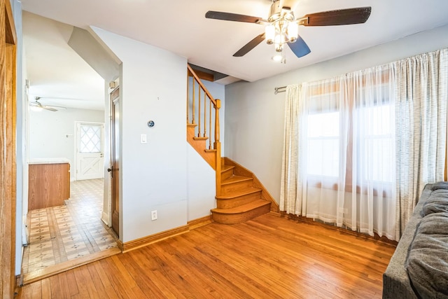 unfurnished living room featuring ceiling fan and wood-type flooring