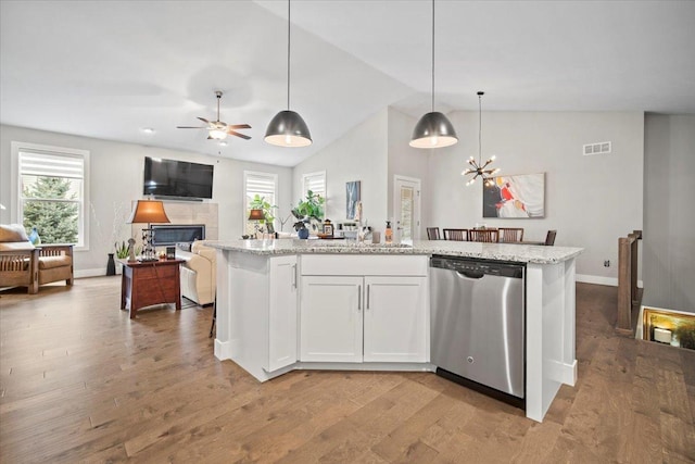 kitchen with dishwasher, hanging light fixtures, light stone counters, an island with sink, and white cabinets