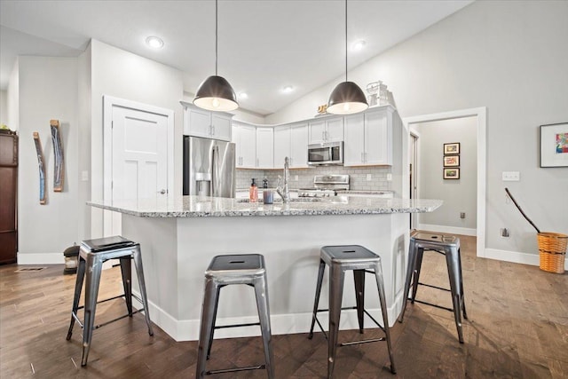 kitchen with pendant lighting, a kitchen breakfast bar, white cabinets, and appliances with stainless steel finishes