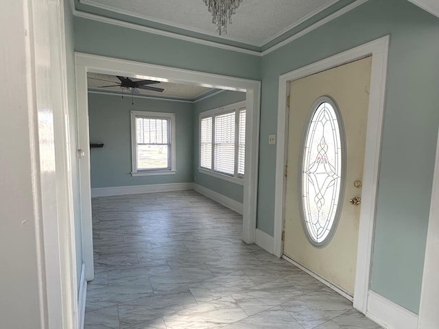 entrance foyer featuring marble finish floor, ceiling fan, baseboards, and crown molding