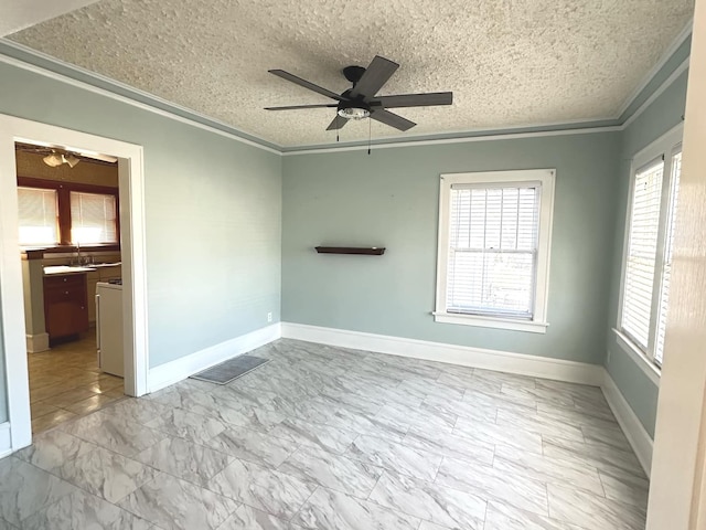 spare room featuring ceiling fan, ornamental molding, a textured ceiling, and a sink