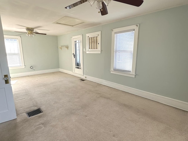 carpeted spare room featuring baseboards, ornamental molding, visible vents, and attic access