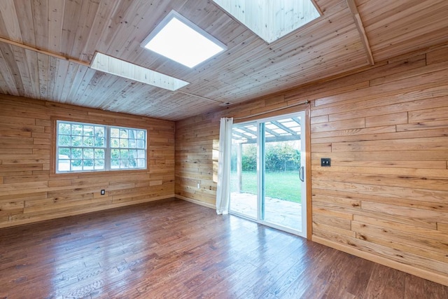 unfurnished room with hardwood / wood-style flooring, wood ceiling, wooden walls, and a skylight