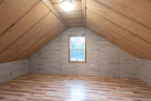 additional living space featuring lofted ceiling and light hardwood / wood-style floors