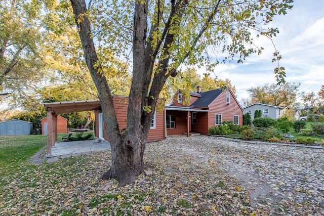 view of front of house featuring a patio area and a shed