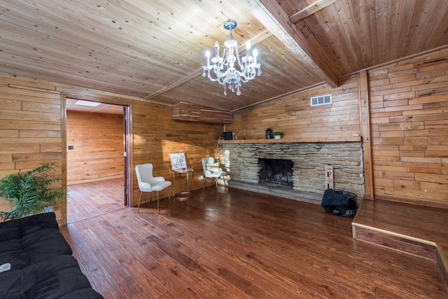 unfurnished living room with hardwood / wood-style floors, wooden walls, a fireplace, vaulted ceiling with beams, and wood ceiling