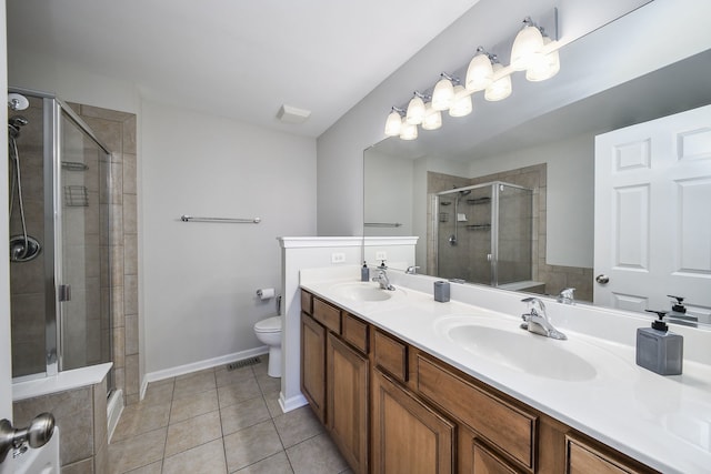 bathroom with vanity, toilet, a shower with shower door, and tile patterned flooring