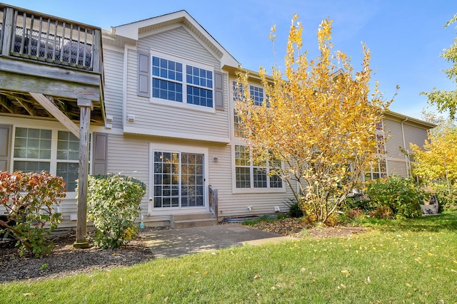 back of house featuring a patio area and a lawn