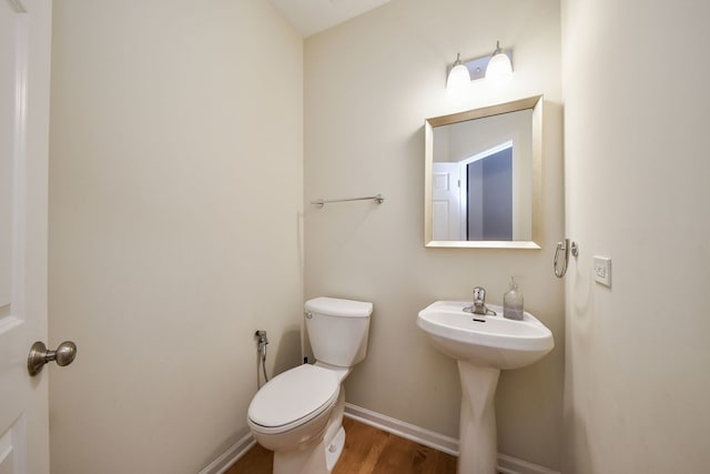 bathroom featuring wood-type flooring and toilet