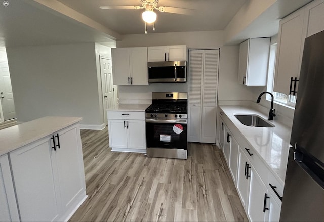 kitchen featuring sink, light hardwood / wood-style floors, white cabinets, and appliances with stainless steel finishes