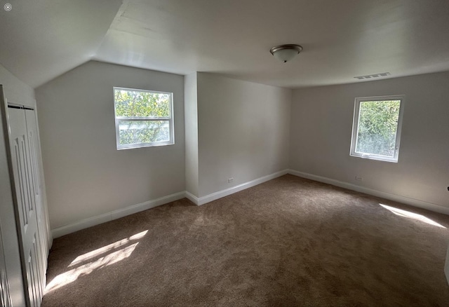 interior space featuring carpet floors and vaulted ceiling