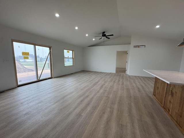 unfurnished living room featuring recessed lighting, lofted ceiling, ceiling fan, and light wood-style flooring