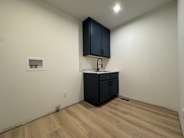 clothes washing area featuring a sink, light wood-type flooring, visible vents, hookup for a washing machine, and cabinet space