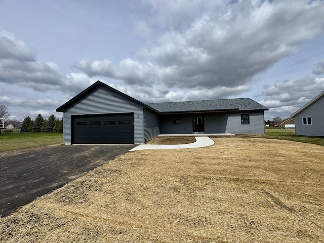 ranch-style home with a front lawn, a shingled roof, a garage, and driveway