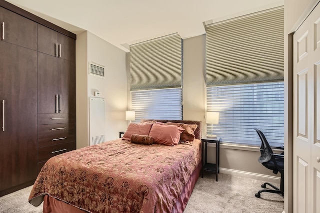 bedroom featuring multiple windows and light carpet