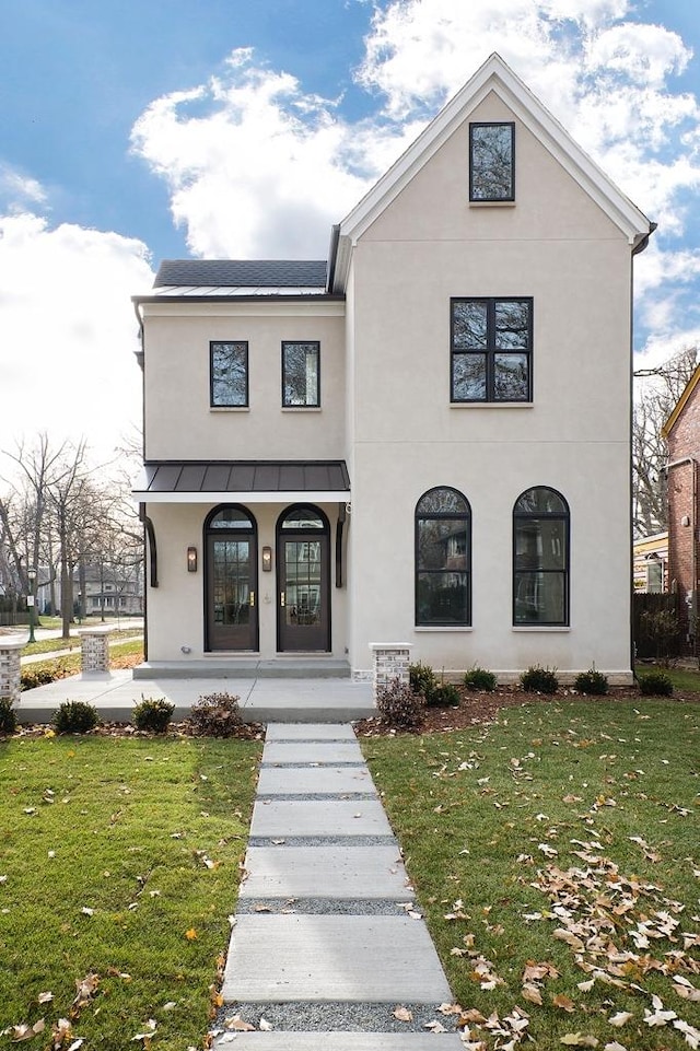 view of front facade with french doors, covered porch, and a front lawn