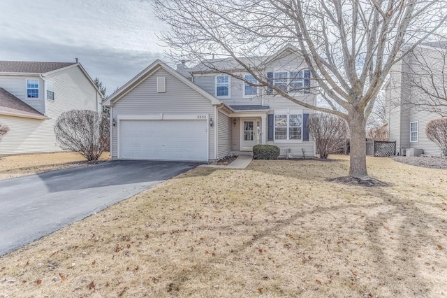 traditional-style home featuring driveway, central air condition unit, and an attached garage