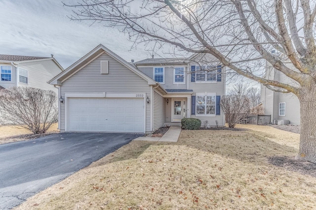 traditional-style home with an attached garage and aphalt driveway