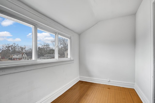 empty room featuring lofted ceiling and hardwood / wood-style floors