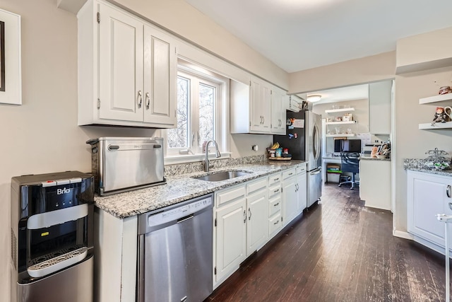 kitchen featuring appliances with stainless steel finishes, white cabinetry, sink, light stone countertops, and dark wood-type flooring