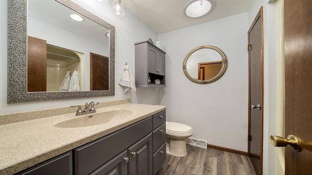 bathroom featuring vanity, hardwood / wood-style flooring, toilet, and walk in shower