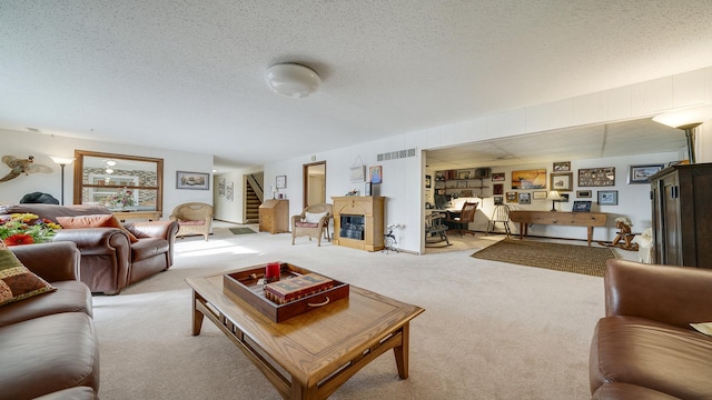 living room featuring light carpet, a textured ceiling, and a fireplace