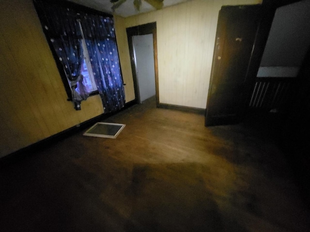 spare room featuring hardwood / wood-style flooring and wooden walls