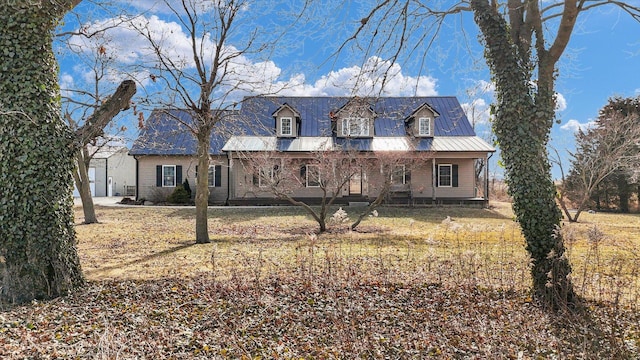 new england style home with metal roof and a front lawn