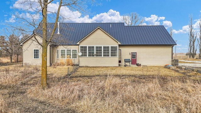 rear view of house featuring a sunroom and metal roof