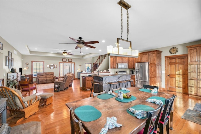 dining space with recessed lighting, light wood finished floors, and stairs