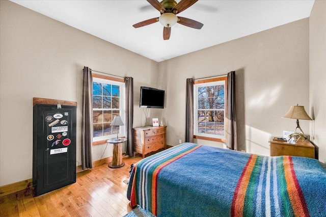 bedroom featuring light wood-type flooring, multiple windows, and baseboards