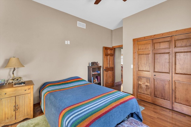 bedroom with a ceiling fan, visible vents, and wood finished floors