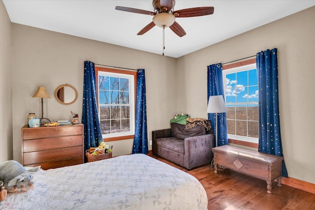 bedroom with ceiling fan, baseboards, and wood finished floors