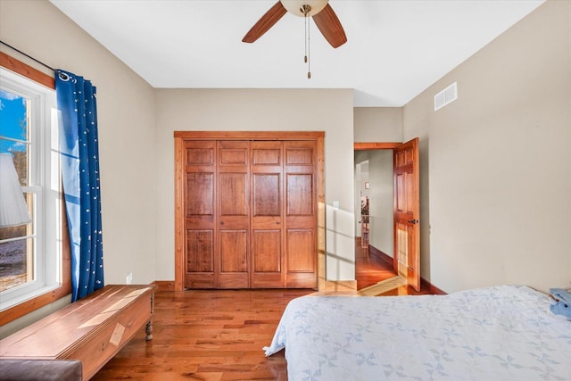 bedroom with a ceiling fan, visible vents, light wood-style flooring, and multiple windows