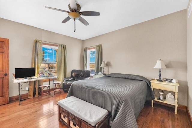 bedroom with ceiling fan, hardwood / wood-style floors, and baseboards