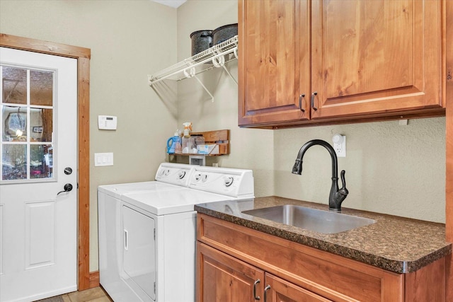 washroom featuring cabinet space, washer and dryer, and a sink