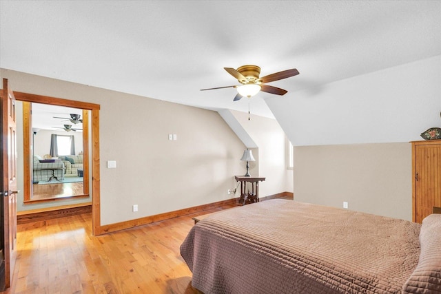 bedroom featuring lofted ceiling, baseboards, ceiling fan, and light wood finished floors