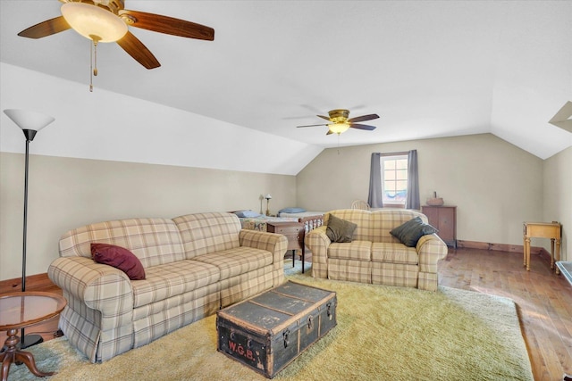 living area featuring baseboards, a ceiling fan, vaulted ceiling, and wood finished floors