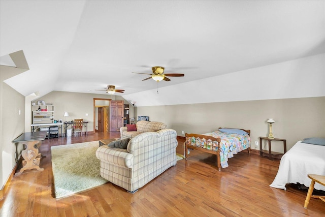 bedroom with vaulted ceiling, baseboards, and wood finished floors