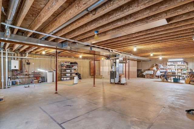 unfinished basement featuring water heater and heating unit