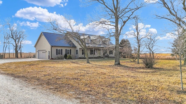 view of front of house with driveway, metal roof, an attached garage, a standing seam roof, and a front yard